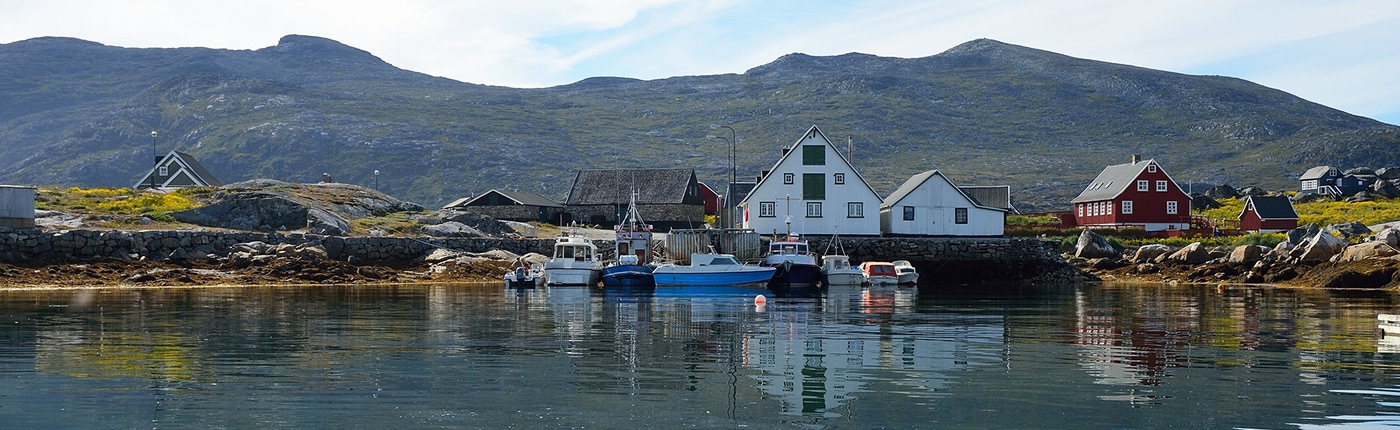 colorful houses and boats on a lake in nanortalik, greenland