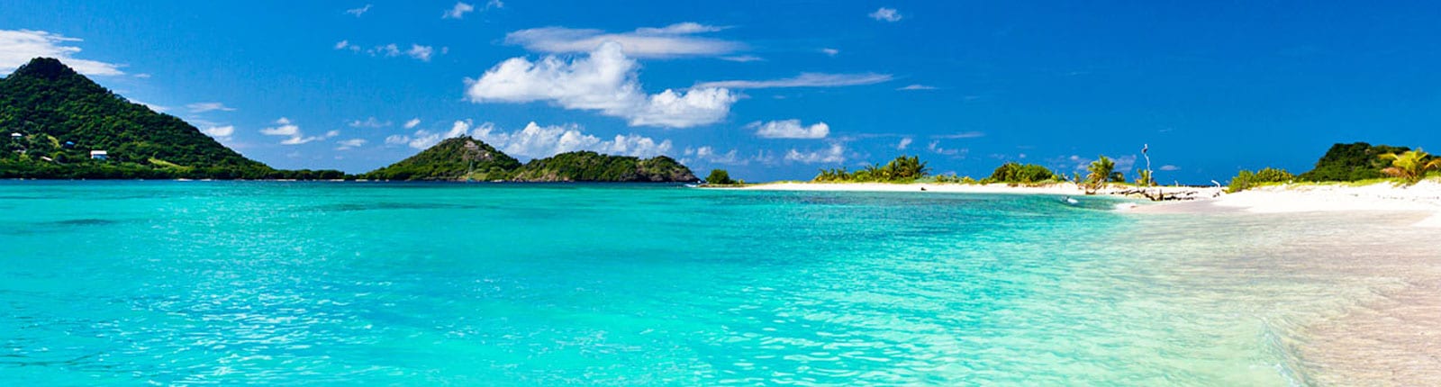 Bright blue water alongside a white sand beach in Grenada