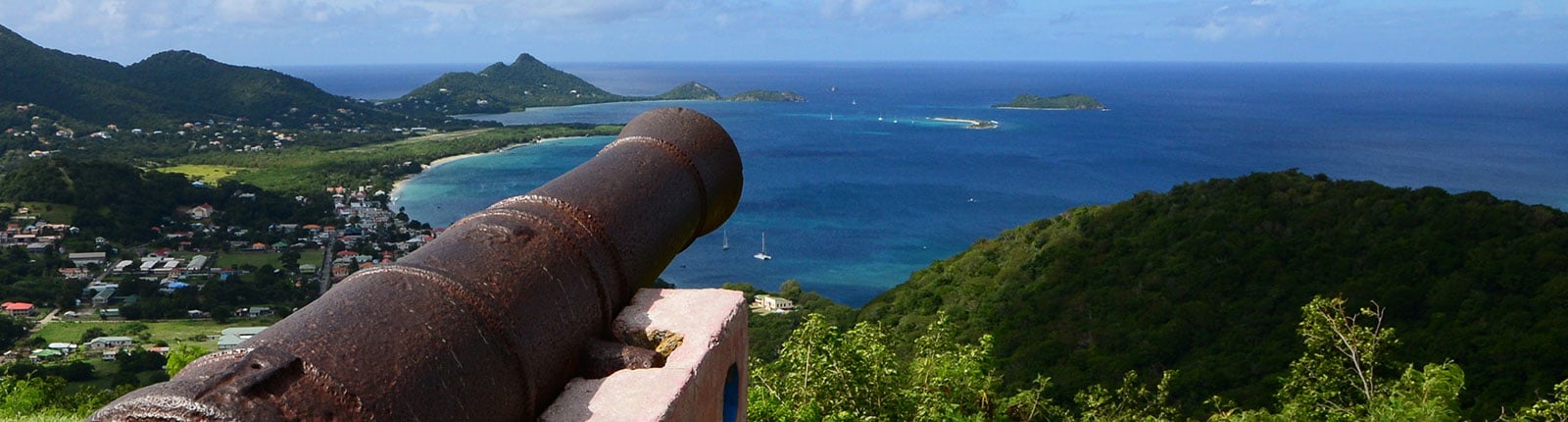 Looking across the barrel of a canon facing the ocean in Grenada