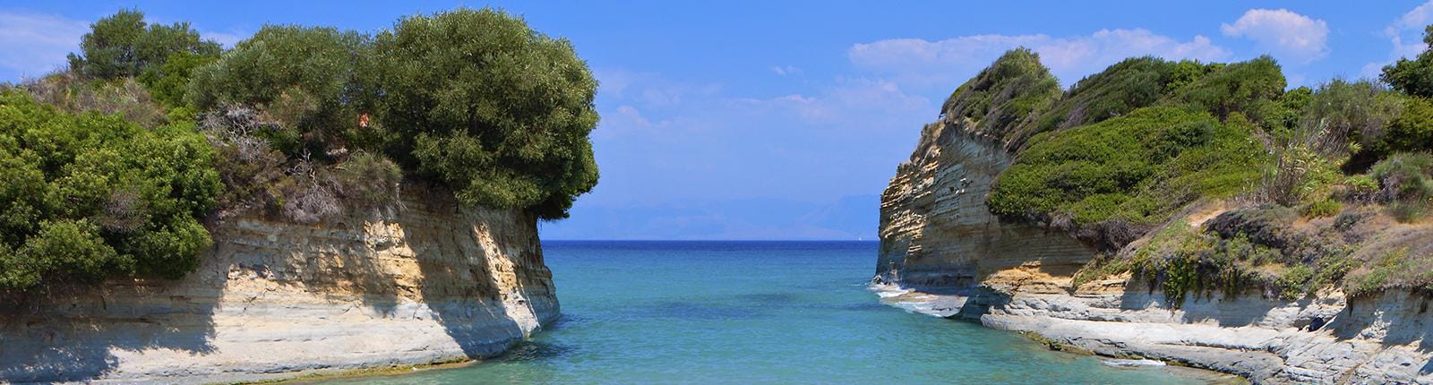 Looking through the stone walls framing the entrance to the sea in Corfu, Greece