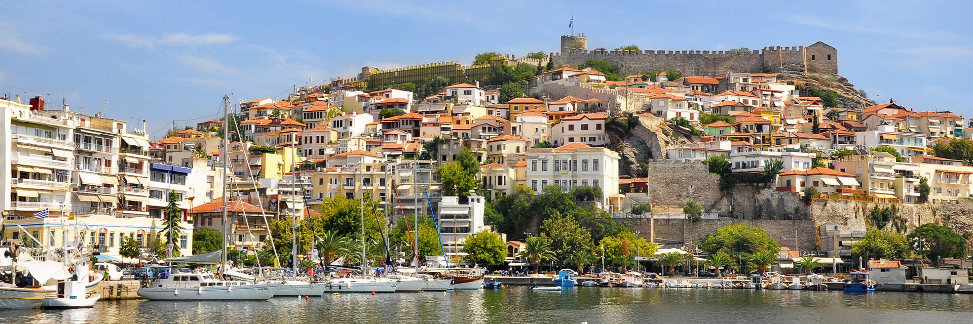 buildings with orange roofs are located on a mountainside of kavala