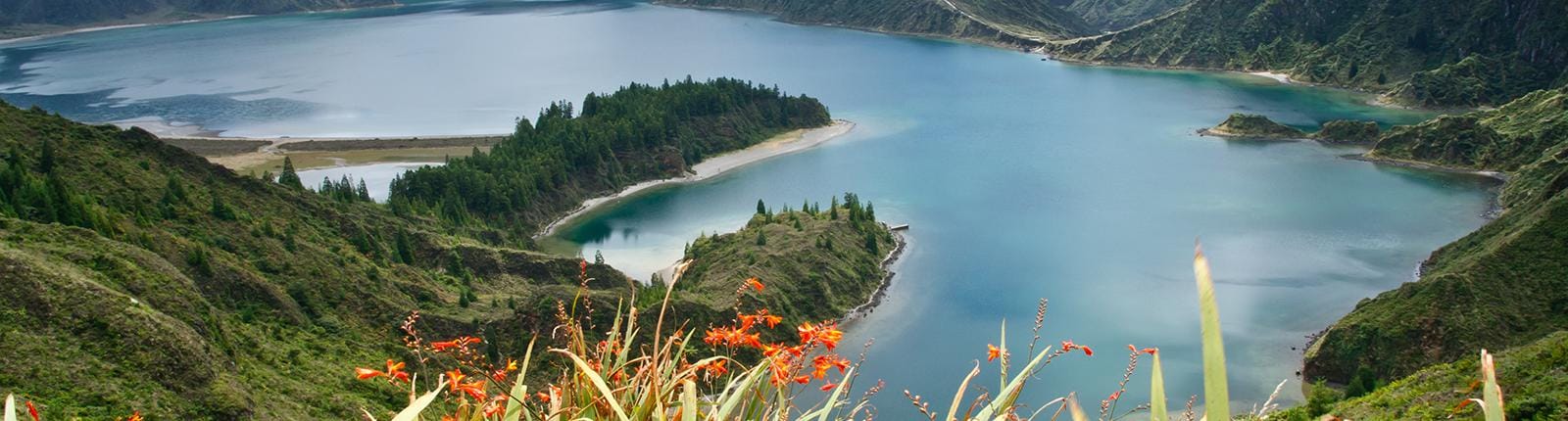 Bright blue waters in the volcanic crater of the Lake of Fire in Ponta Delgada, Portugal