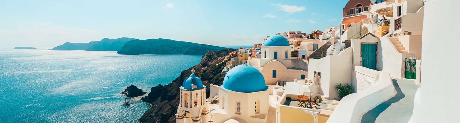 white buildings along the teal coastline of santorini, greece