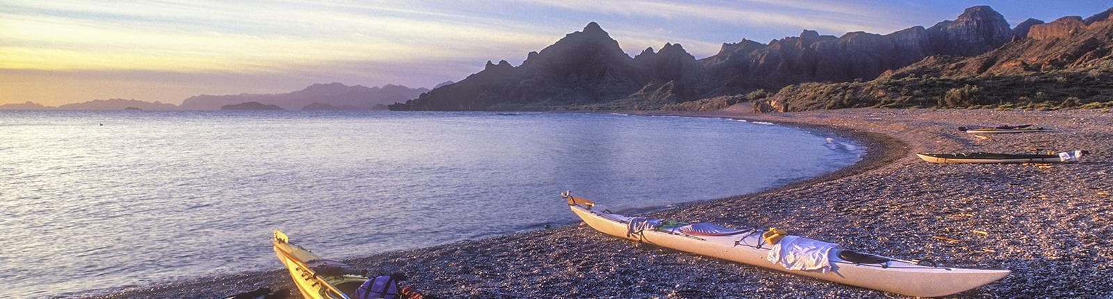 Vacant row boats with mountains in the background overlooking the waters of La Paz, Mexico