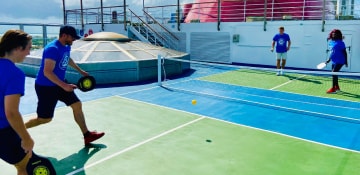 guests playing a fun game of pickleball on a carnival cruise ship