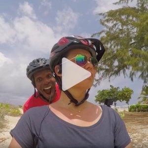 Man and woman taking a selfie while biking on the beach, link to Youtube video