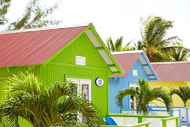 pastel colored private beach bungalows in princess cays
