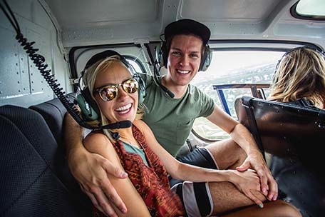 Brad and Hailey smiling while in a helicopter in Grand Cayman