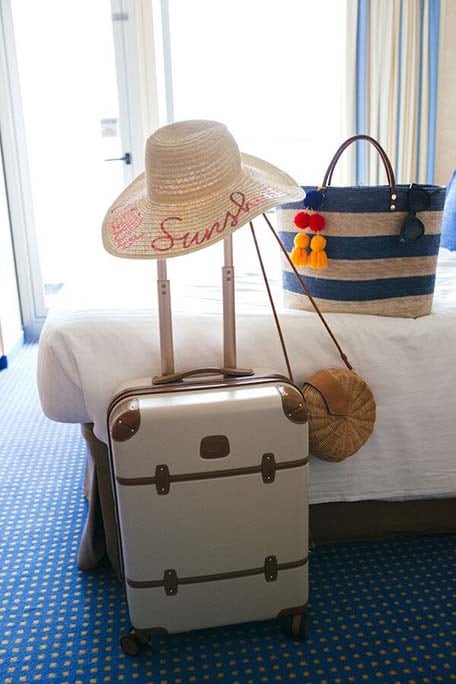 Suitcase, beach bag and sun hat inside a balcony stateroom on the Carnival Victory