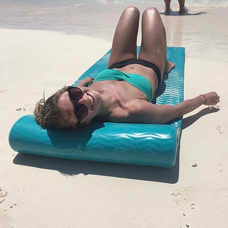 Sarah laying on a beach float on the beach