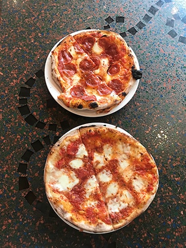 two plates of pizza on counter