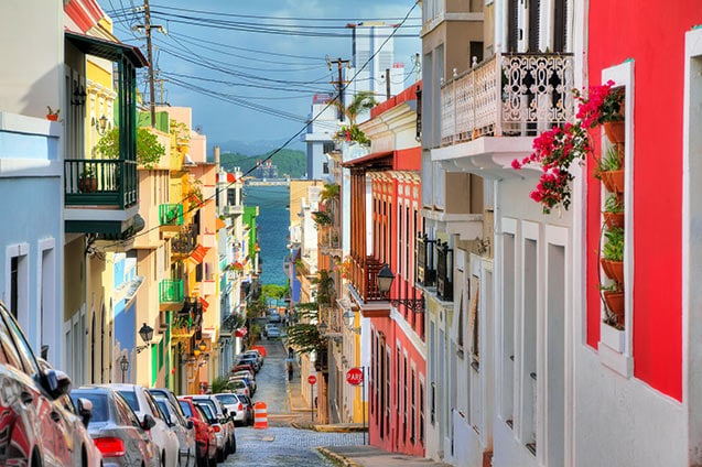 small block of colorful houses along a street in old san juan that ...