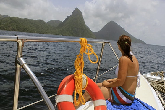 woman looking at st lucia’s two pitons during a catamaran cruise