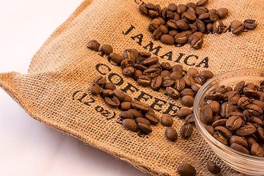 coffee beans over a 12oz bag of jamaican coffee
