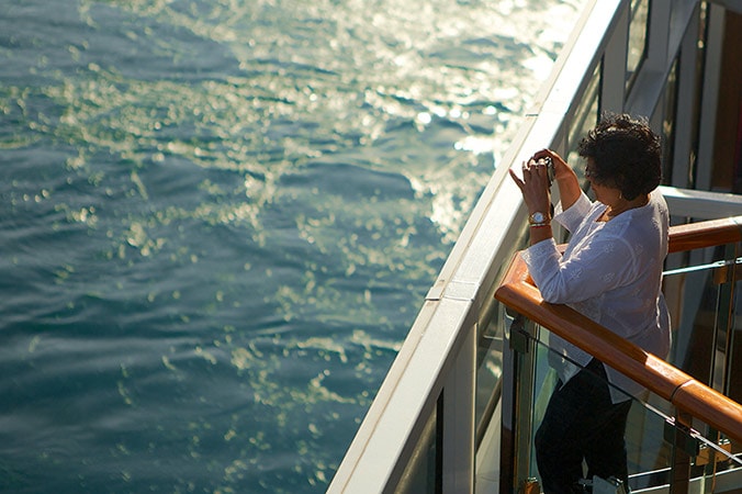 woman taking photos on the deck of a carnival cruise