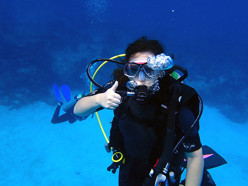 woman giving a thumbs up during a scuba dive in Bonaire