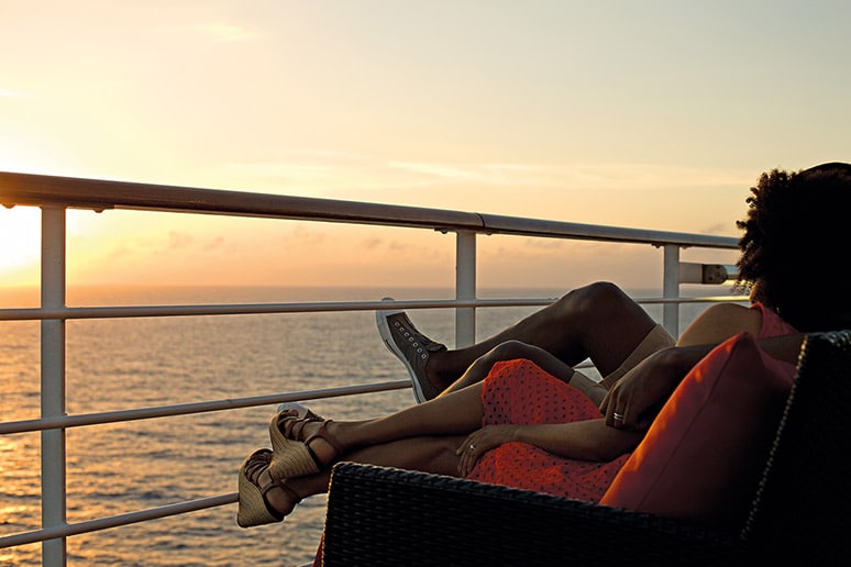 couple staring at the sunset on a cruise