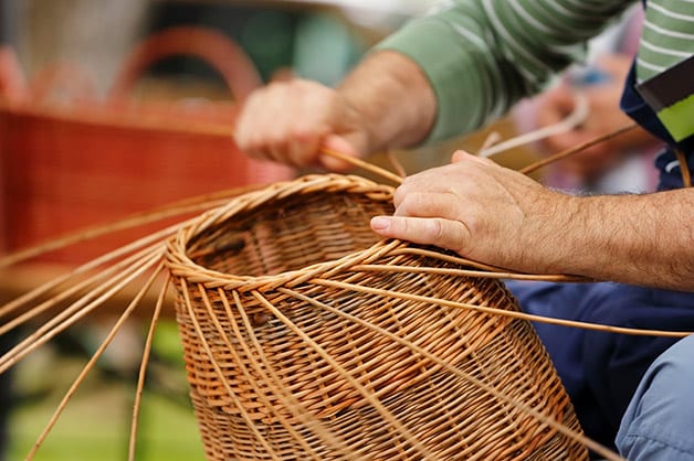 man making handwoven baskets from straw