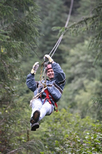man ziplining through the tongass national forest in juneau alaska