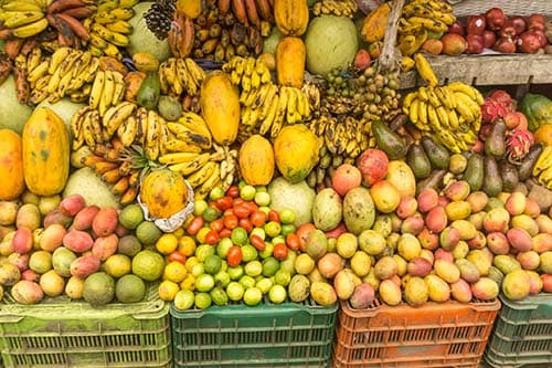variety of fresh fruits being sold in dominica including bananas, mangos, and papayas