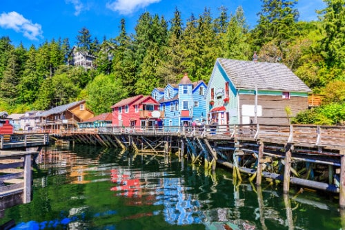 colorful buildings built on a wood foundation along the water in ketchikan alaska
