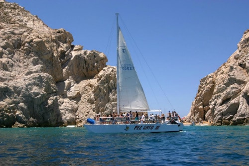 group of people having fun on a white sail boat in cabo san lucas