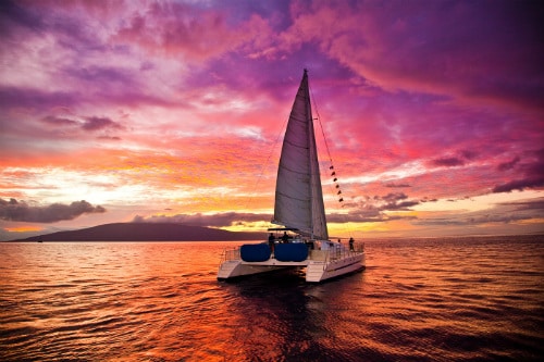 catamaran sailing through the ocean during the sunset near maui