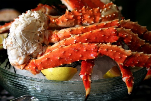 alaskan king crab legs served on ice bucket with lemon