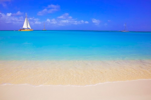 3 yachts sailing pass the sky blue waters of love beach in nassau bahamas