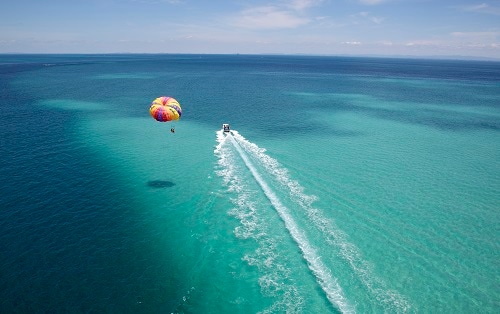 aerial view of couple parasailing on the open mexican waters 