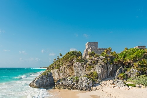 side view of the pyramid of tulum across the beach near cozumel mexico