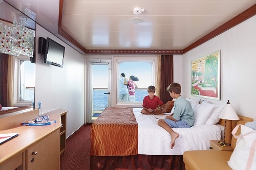 kids playing cards in the family stateroom as their parents enjoy the balcony 