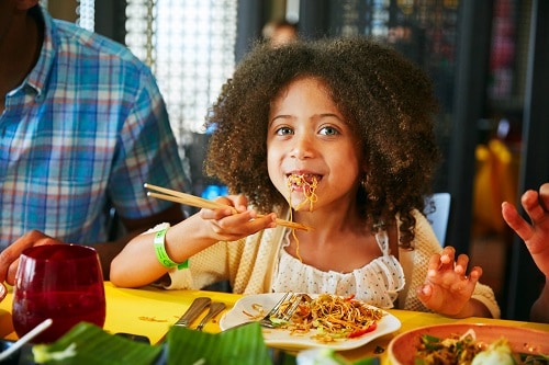 little girl eating chow mein from jiji kitchen on a carnival cruise ship 