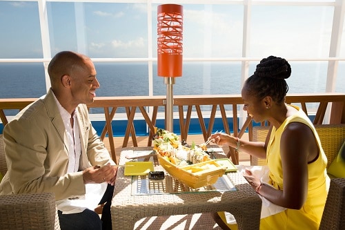couple eating from bonsai sushi with a view of the ocean on carnival spirit 