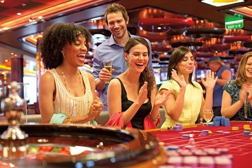 group of friends playing on the roulette table onboard carnival’s casino