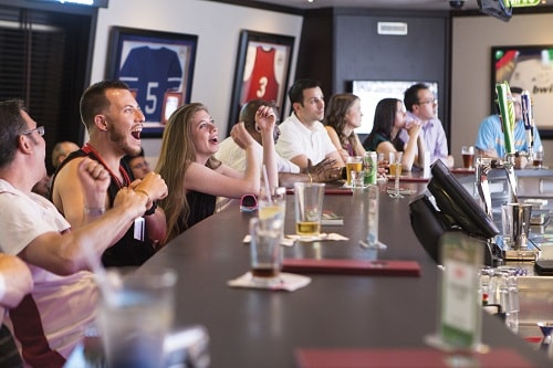 guests celebrating as the watch their favorite team play at skybox sports bar