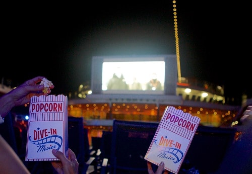 guests eating popcorn as they watch a movie on carnival’s seaside theater