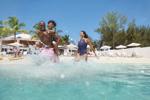 family splashing in the waters in the bahamas