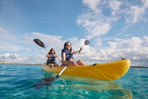 two young girls kayaking on the ocean