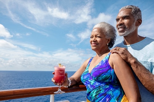 senior couple enjoying the ocean view with a drink