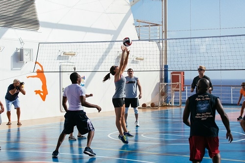 group of people playing volleyball at sportsquare onboard a carnival ship