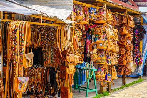 leather belts and backpacks on sale in a market in oaxaca, mexico
