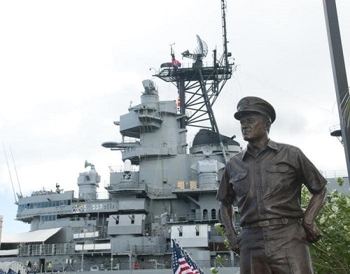 a bronze statue of a soldier in front of the pearl harbor visitors center