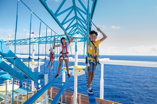 a family making their way through the ropes course onboard a carnival ship