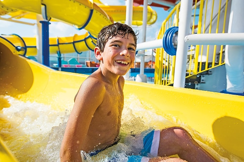 a young boy getting off the twister waterslide
