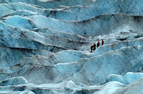 travelers hiking to an alaskan glacier