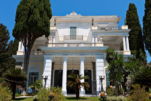 a full view of the achilleion palace and surrounding trees in corfu