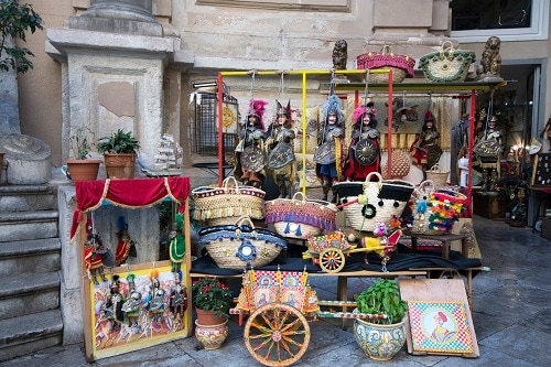 a souvenir cart with handbags and puppets in palermo, italy