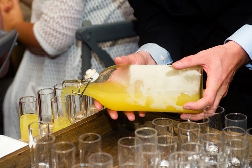 a waiter pouring a glass of limoncello 