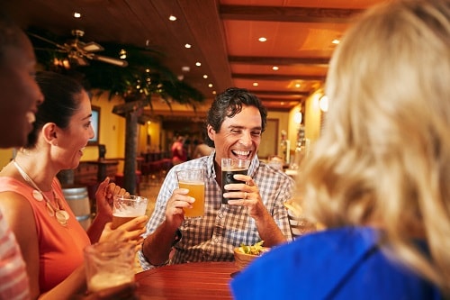 group of people laughing and drinking beer at the redfrog pub